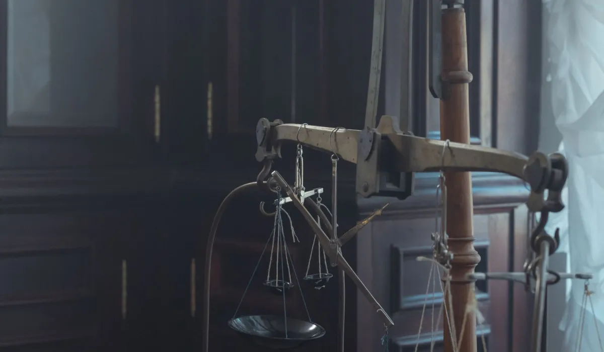 Illustration of an old balance scale weighing a stack of papers against a single feather